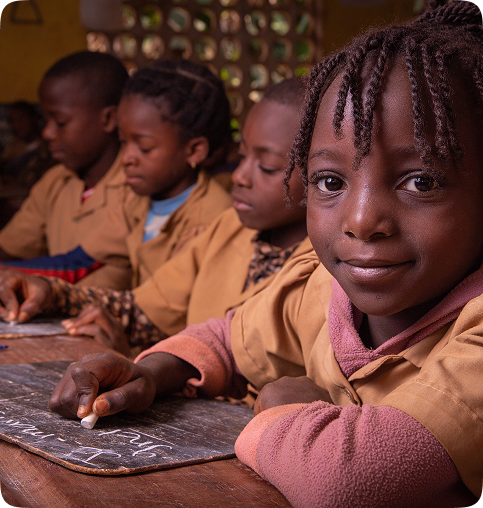 Crianças africanas e brasileiras participando de atividade educacional com sorrisos e cadernos nas mãos